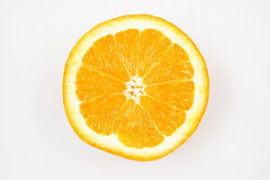 Image of an orange fruit half on a white background.
